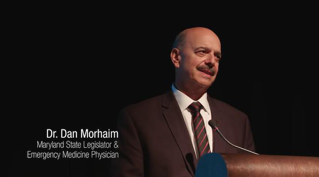 Dr. Dan Morhaim standing at a podium and giving a speech, featured in Painkiller: Inside the Opioid Crisis.